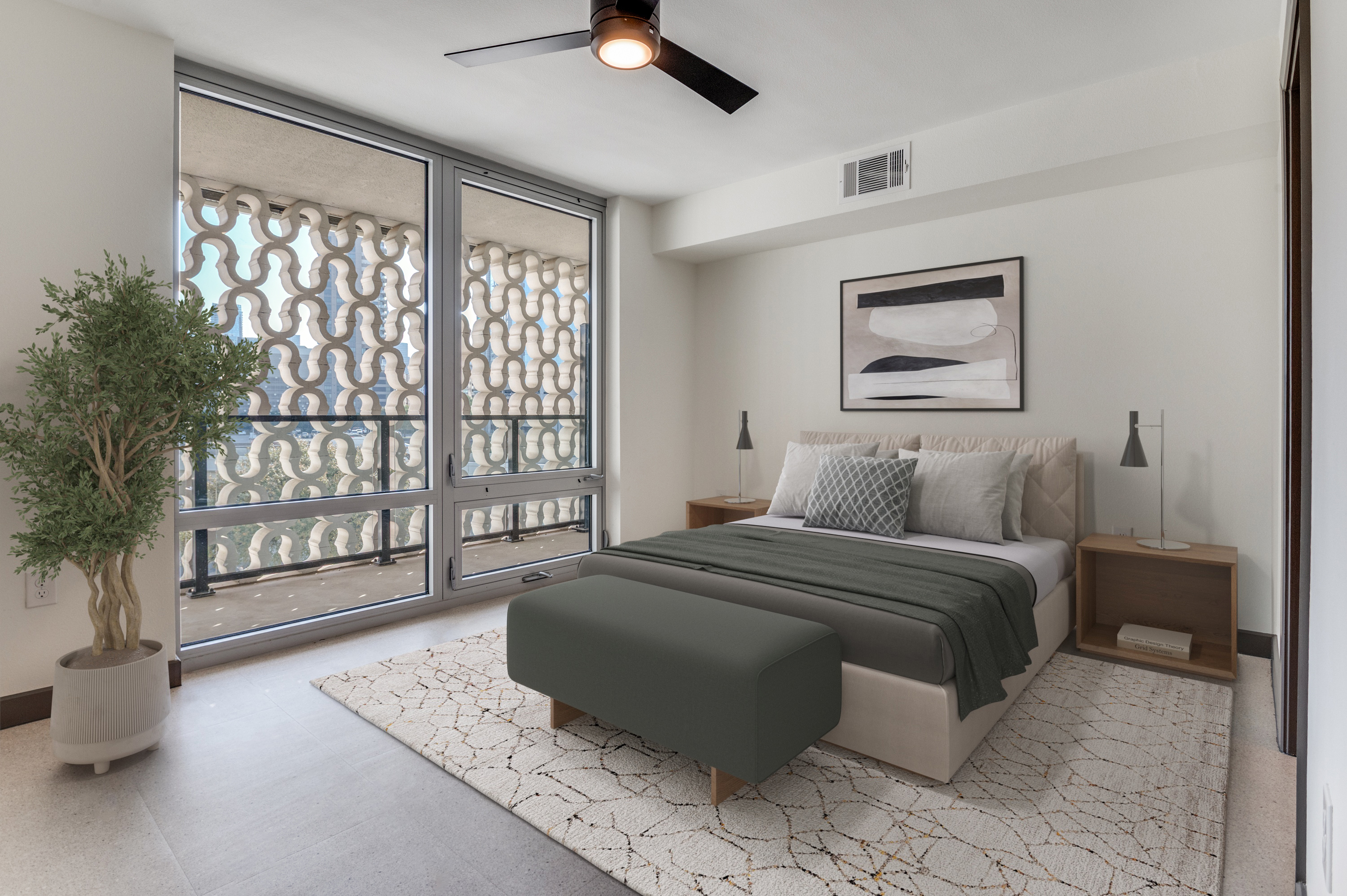 Modern bedroom in Dallas Apartments with a large window, patterned balcony screen, double bed, two nightstands with lamps, abstract wall art, potted plant, and a ceiling fan—perfect for Cabana Design District living.